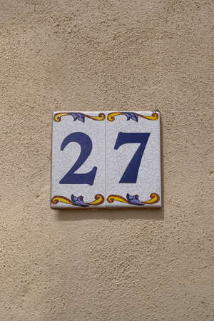 decorated ceramic tiles 27 house number on cream rough wall