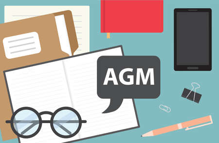 AGM (Annual General Meeting) written in speech bubble on office desk - vector illustrationのイラスト素材