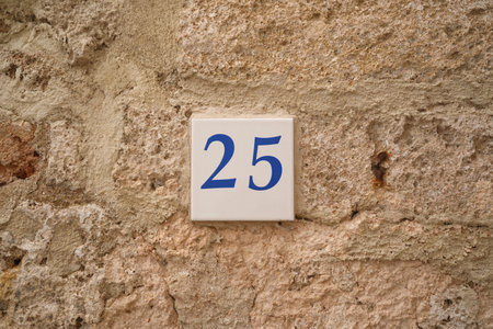 25 ceramic number plate on old stone wallの写真素材
