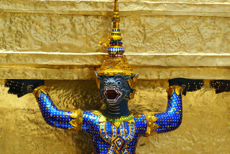 a golden thai angel statue inside grand palace in Bangkokの写真素材