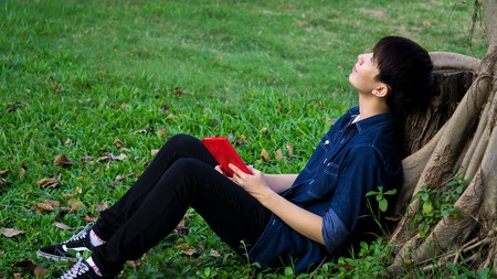 Resting time. Asian young man looking at the sky after study against his text book.