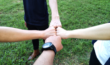Close up view of young people putting their hands together. Friends with stack of hands showing...