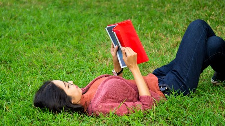 Young woman reading a book and relaxing at the park
