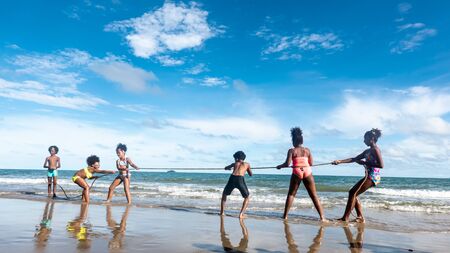 Kids playing running on sand at the beach