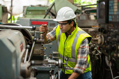 Factory Engineers operating a cnc machine in factory