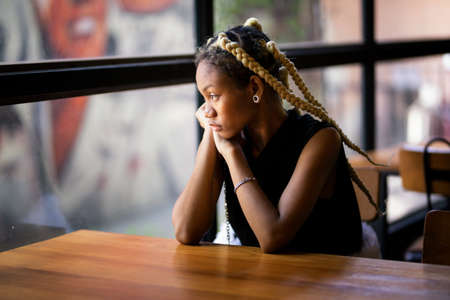 Portrait of Afro young women sitting by window and look awayの写真素材