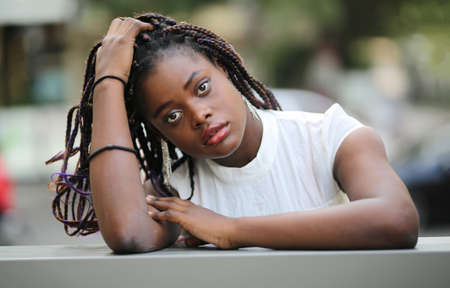 Portrait of young Afro women  standing with white dress at street.