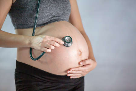 Cropped Hand of Examining Pregnant Woman Belly With Stethoscope