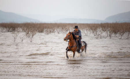 cowboy and horse at first light,mountain, river and lifestyle with natural light background.の写真素材