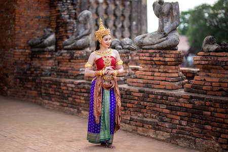Beautiful Thai girl in Thai traditional costume. Asia woman wearing traditional Thai dress,The costume of the national dress of ancient Thailand against temple.の写真素材