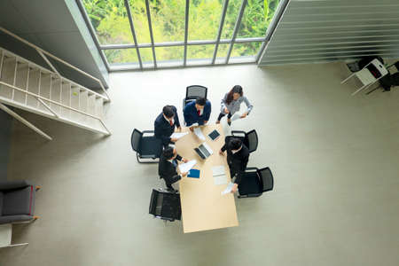 Top view on a group of businessman and businesswoman having a meeting and making a business commitment.の写真素材