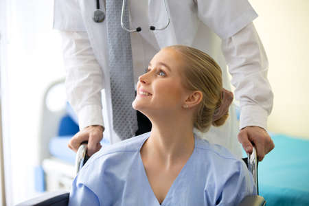 Doctor check up and discuss with female patient sit on wheelchair in clinic or doctor talk with...