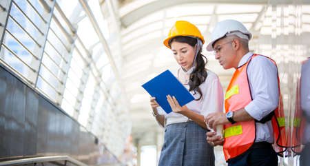 Construction engineers discussion with architects at construction site or building site of high-rise...
