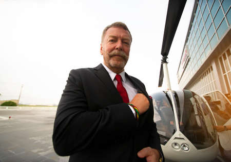 Business people traveling by helicopter , Shot of a mature businessman using a headset while...