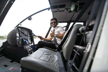 Shot of a mature Helicopter pilot using a headset while traveling in a helicopter, Business people traveling by helicopterの写真素材