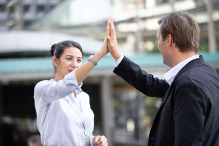 The business people hand high five against building.