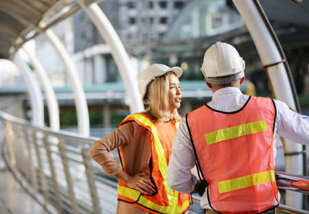 Female industrial engineer wearing a white helmet while standing in a construction site with...