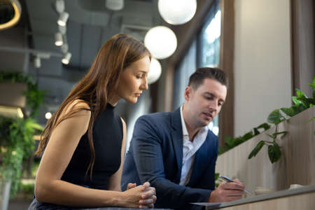 business partners discussing documents and ideas at meetingの写真素材