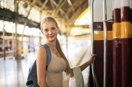 young woman waiting in vintage train, relaxed and carefree at the station platform in Bangkok, Thailand before catching a train. Travel photography. Lifestyle.の写真素材