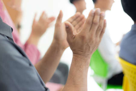 Close up of business people clapping hands during a meeting in the office