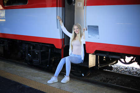 young woman waiting in vintage train, relaxed and carefree at the station platform in Bangkok, Thailand before catching a train. Travel photography. Lifestyle.の写真素材