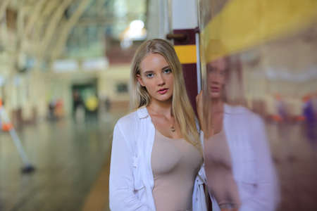 young woman waiting in vintage train, relaxed and carefree at the station platform in Bangkok,...