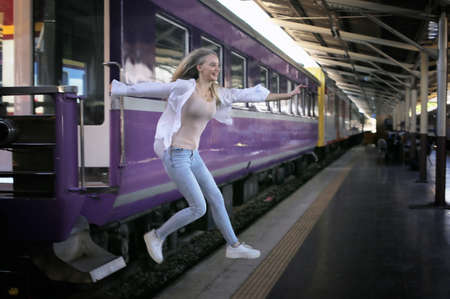 young woman waiting in vintage train, relaxed and carefree at the station platform in Bangkok, Thailand before catching a train. Travel photography. Lifestyle.の写真素材