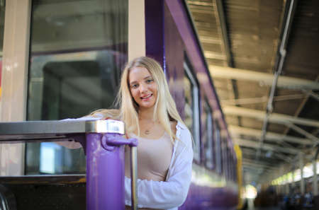 young woman waiting in vintage train, relaxed and carefree at the station platform in Bangkok, Thailand before catching a train. Travel photography. Lifestyle.の写真素材