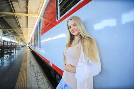 young woman waiting in vintage train, relaxed and carefree at the station platform in Bangkok, Thailand before catching a train. Travel photography. Lifestyle.の写真素材