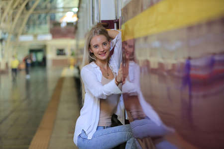 young woman waiting in vintage train, relaxed and carefree at the station platform in Bangkok,...