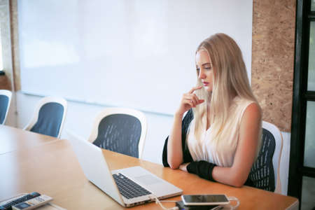 Smiling woman using laptop in work place for small businesses looking to engage audiences and scale...