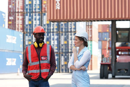 Foreman control loading Containers box from Cargo freight ship for import export. Freight containers in sea port.の写真素材