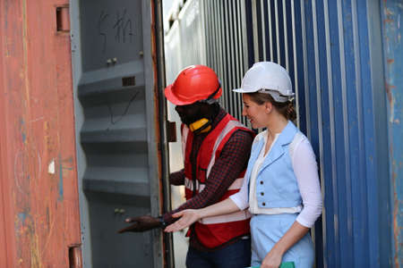 Foreman control loading Containers box from Cargo freight ship for import export. Freight containers in sea port.の写真素材