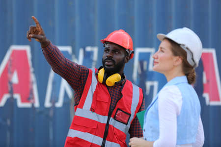 Foreman control loading Containers box from Cargo freight ship for import export. Freight containers...