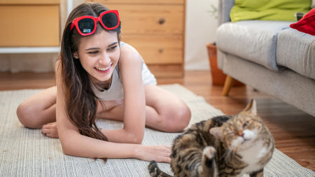 Young happy wirl play with cat in room.の写真素材