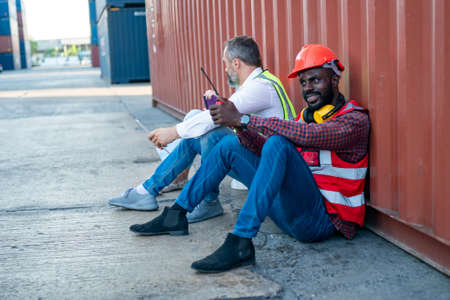 Foreman control loading Containers box from Cargo freight ship for import export. Freight containers in sea port.の写真素材