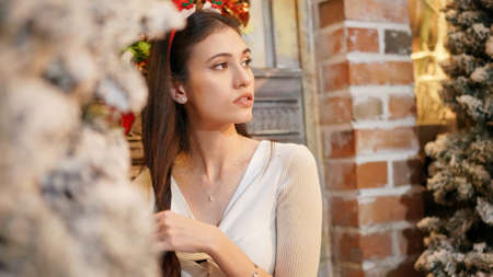 Fashion young beautiful woman in knitted dress near Christmas tree. Fashion beautiful sensual new...
