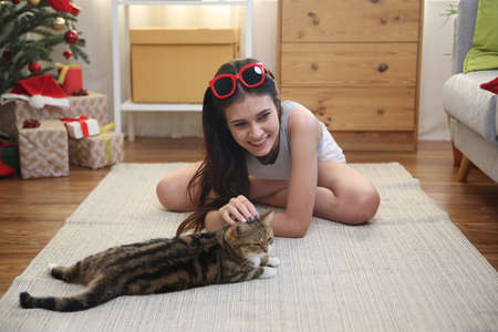 young woman play with cat in room on floor.の写真素材