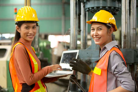 Hard-working engineer holding digital tablet in hands while working in manufacturing plant, profile...