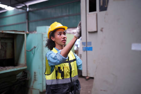 Female apprentice in metal working factory, Portrait of working female industry technical worker or engineer woman working in an industrial manufacturing factory company.の写真素材