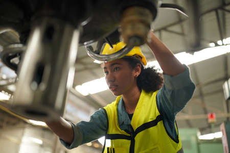 Female apprentice in metal working factory, Portrait of working female industry technical worker or...