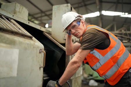 Male engineer metalworker industrial experienced operator technician worker in safety hard helmet...