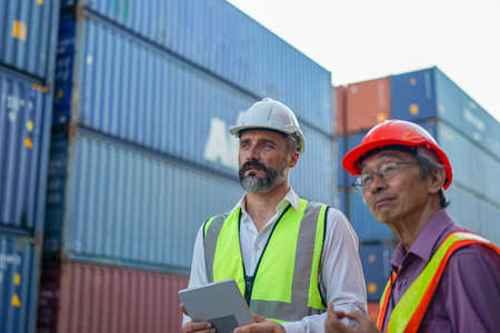 Foreman control loading Containers box from Cargo freight ship for import export.