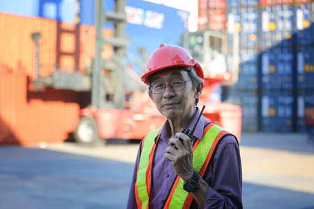Foreman control loading Containers box from Cargo freight ship for import export.