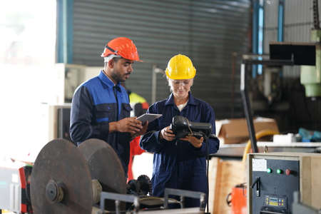 engineer checking control panel and teaching new Automatics robot arm and operating control machine in factory.の写真素材