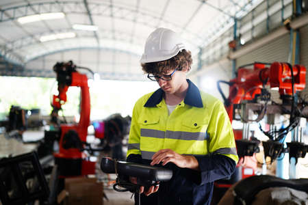 engineer checking control panel and teaching new Automatics robot arm and operating control machine...