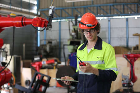engineer checking control panel and teaching new Automatics robot arm and operating control machine...