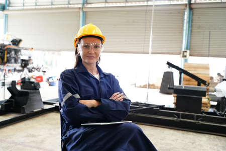 Female industrial worker working with manufacturing equipment in a factoryの写真素材