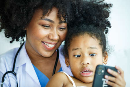 Portrait of a Brilliant Black Girl with Braces Writes in Exercise Notebook, Smiles. Junior Classroom...