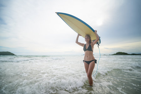 Woman with surfboard on the beachの写真素材